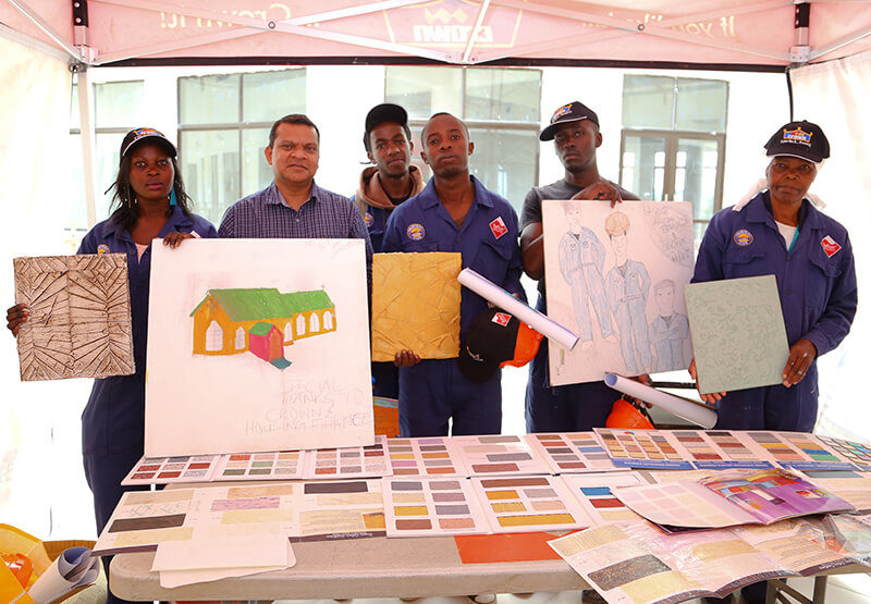 Crown Paints Group Marketing Manager, Nilesh Gosavi poses with the Housing Finance Graduates while displaying their designs.