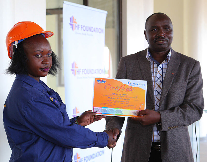 Director General TVETA, Dr. Kipkirui Langat presents a certificate to one the students during the Housing Finance Graduation Ceremony.