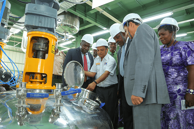 Crown Paints Kisumu- Factory Head, Shailesh Patel shows His Excellency the Governor of Kisumu, Hon Jack Raguma (second right) and the Crown Paints CEO, Rakesh Rao how some of the Paint machines functions.